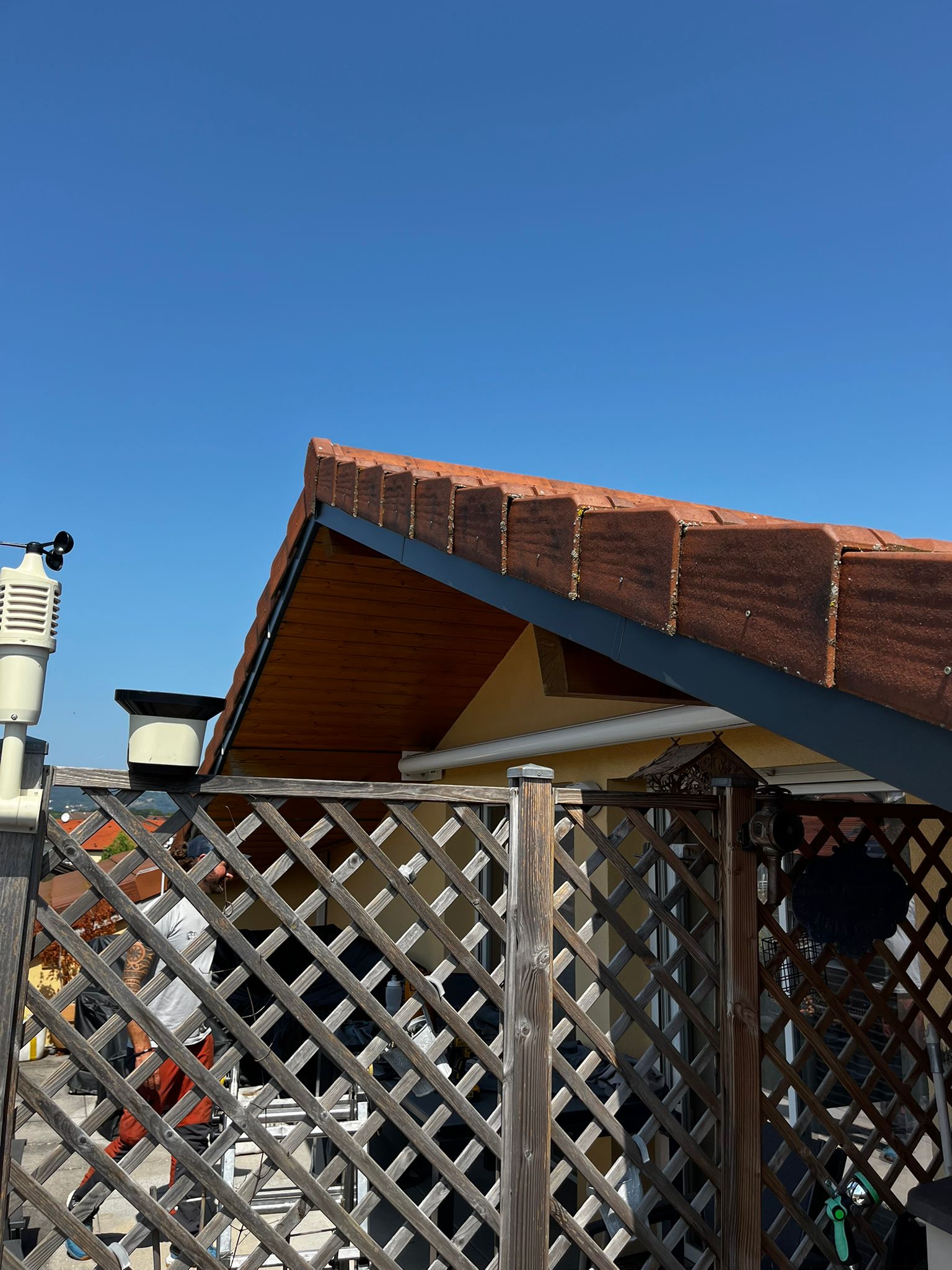 Détail d'une toiture de maison montrant l'entretien des planches de rive et le traitement des boiseries sous toiture.